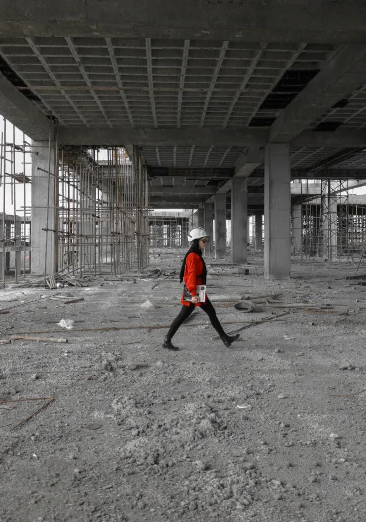 A worker marches through a construction site with Masonry Walls.