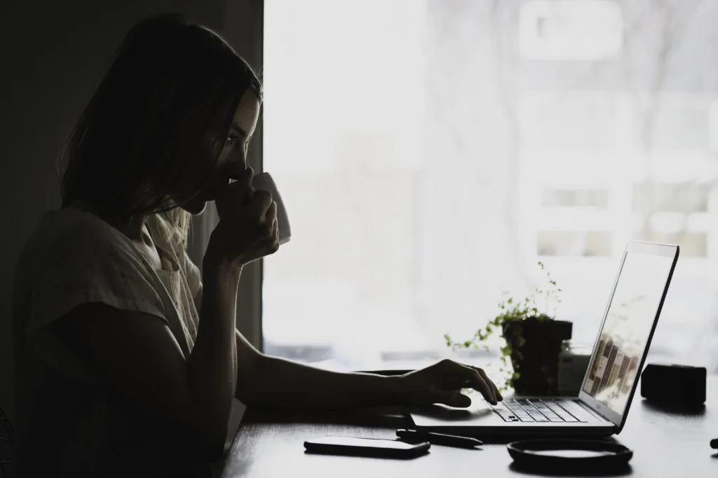 A woman sits at the computer.